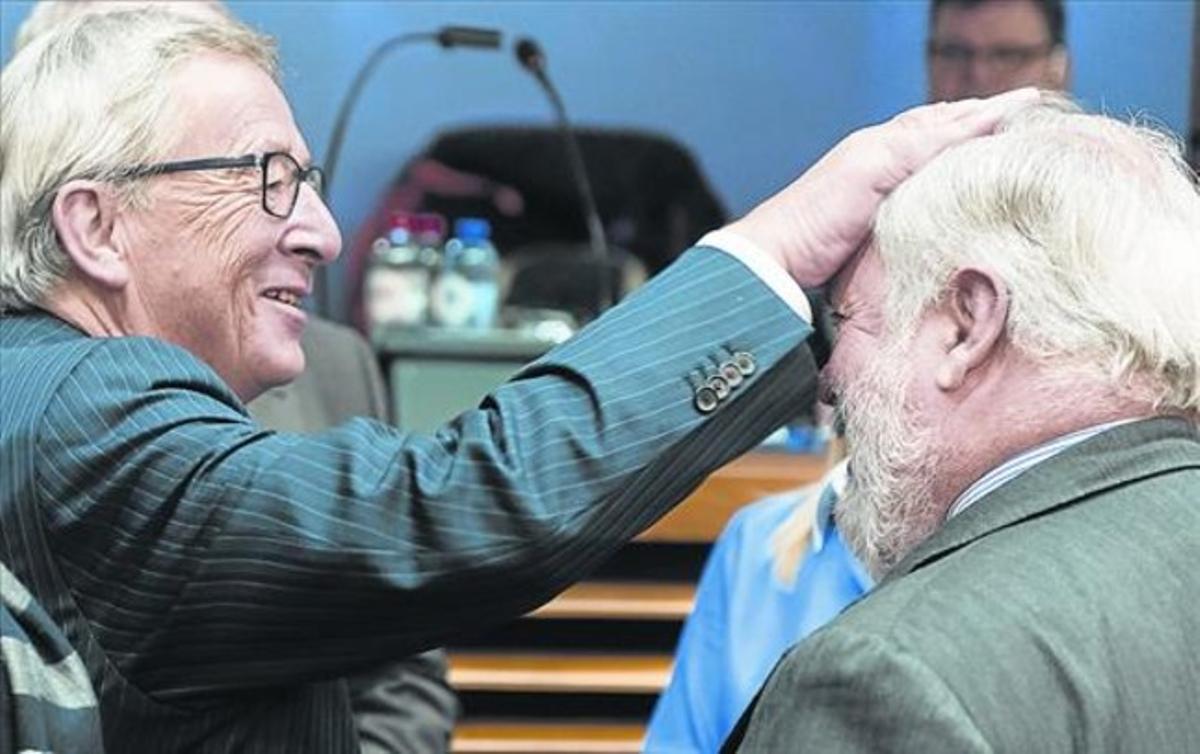 Juncker hace un gesto cariñoso hacia Cañete, ayer en Bruselas.