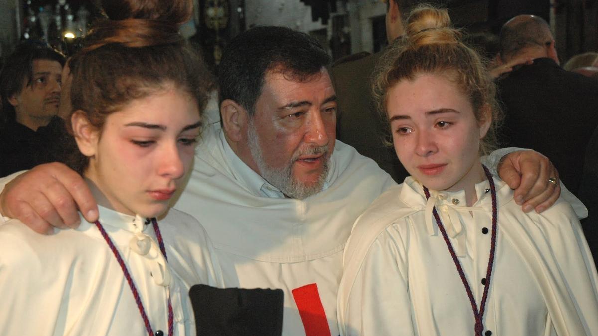 El director espiritual de la Hermandad de San Pablo consuela a dos pequeñas nazarenas