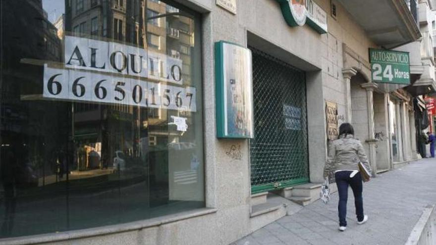 Una mujer observa el cartel de &#039;se alquila&#039; expuesto en un bajo vacío. / r. grobas