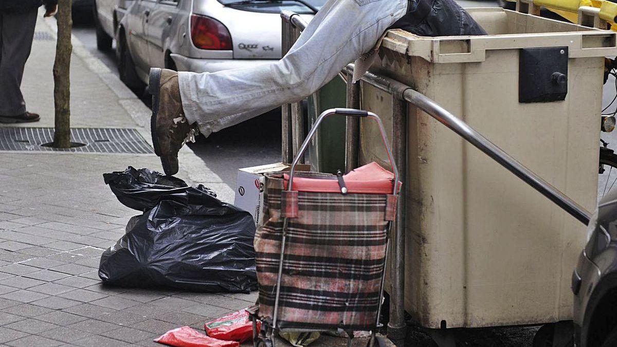 Un hombre rebusca en la basura en A Coruña.