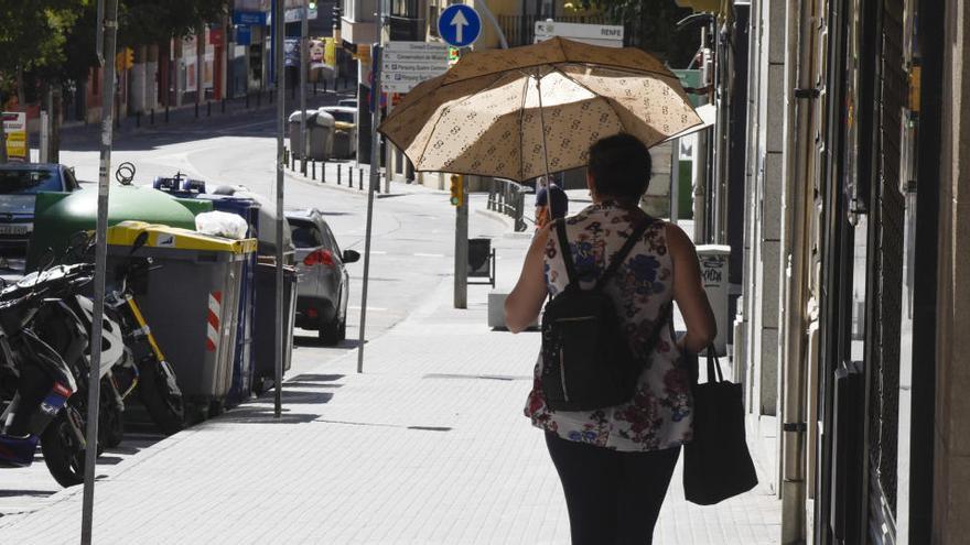 Una dona amb paraigües per protegir-se del sol, a Manresa, l&#039;agost passat