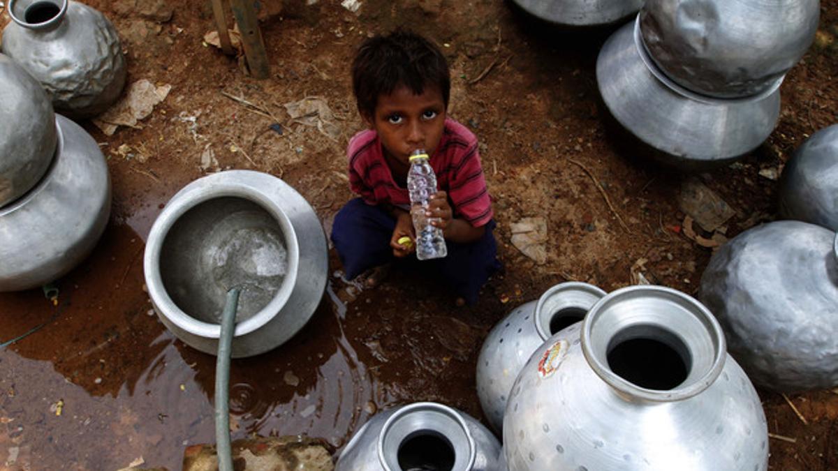 Un niño indio recoge agua en un depósito gubernamental en Bhubaneswar, este sábado.