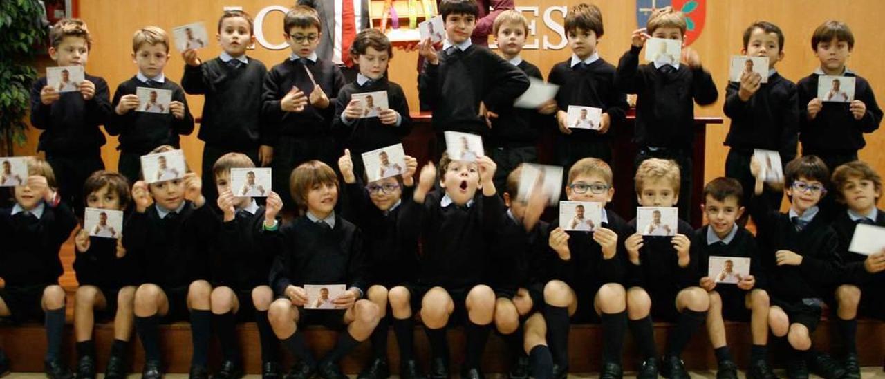 El director del colegio, Ángel Gallo, y Saúl Craviotto, con las medallas, posan con los alumnos de primero de Primaria de Los Robles.