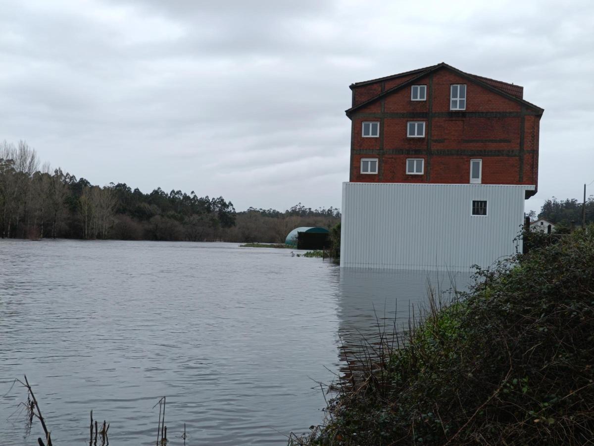 Vivienda rodeada por el agua tras el desbordamiento del río Grande, en Torelo - Vimianzo.