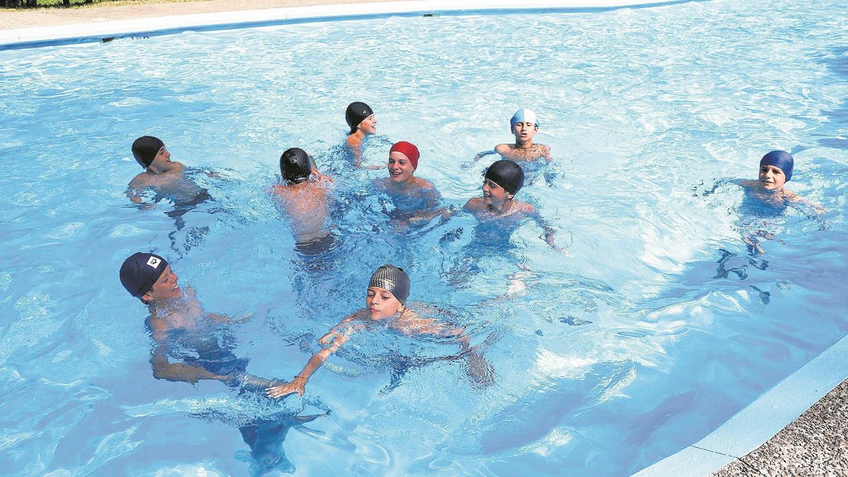 Un grupo de niños disfruta en el agua.