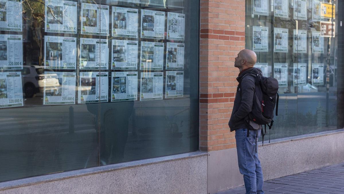 Un hombre observa los precios de los pisos en una inmobiliaria de València, ayer.