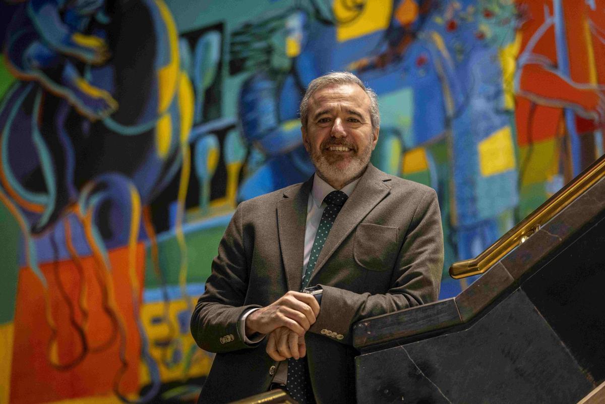 Jorge Azcón, en la escalinata que da acceso a la Sala de Columnas del Pignatelli, con el mural de Jorge Gay al fondo.
