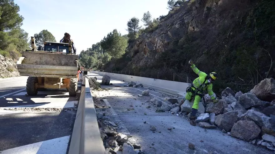 Operaris treballen per retirar les roques caigudes d'un talús a la C-58