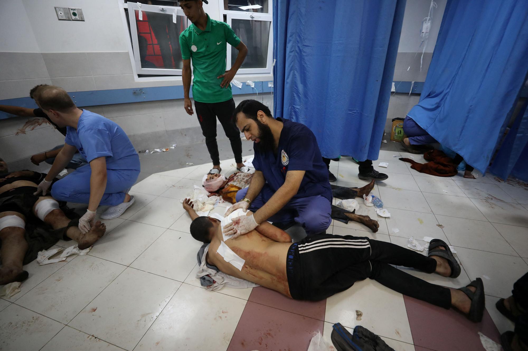 Injured people are assisted after Israeli air strike hit a hospital, according to Gaza Health Ministry