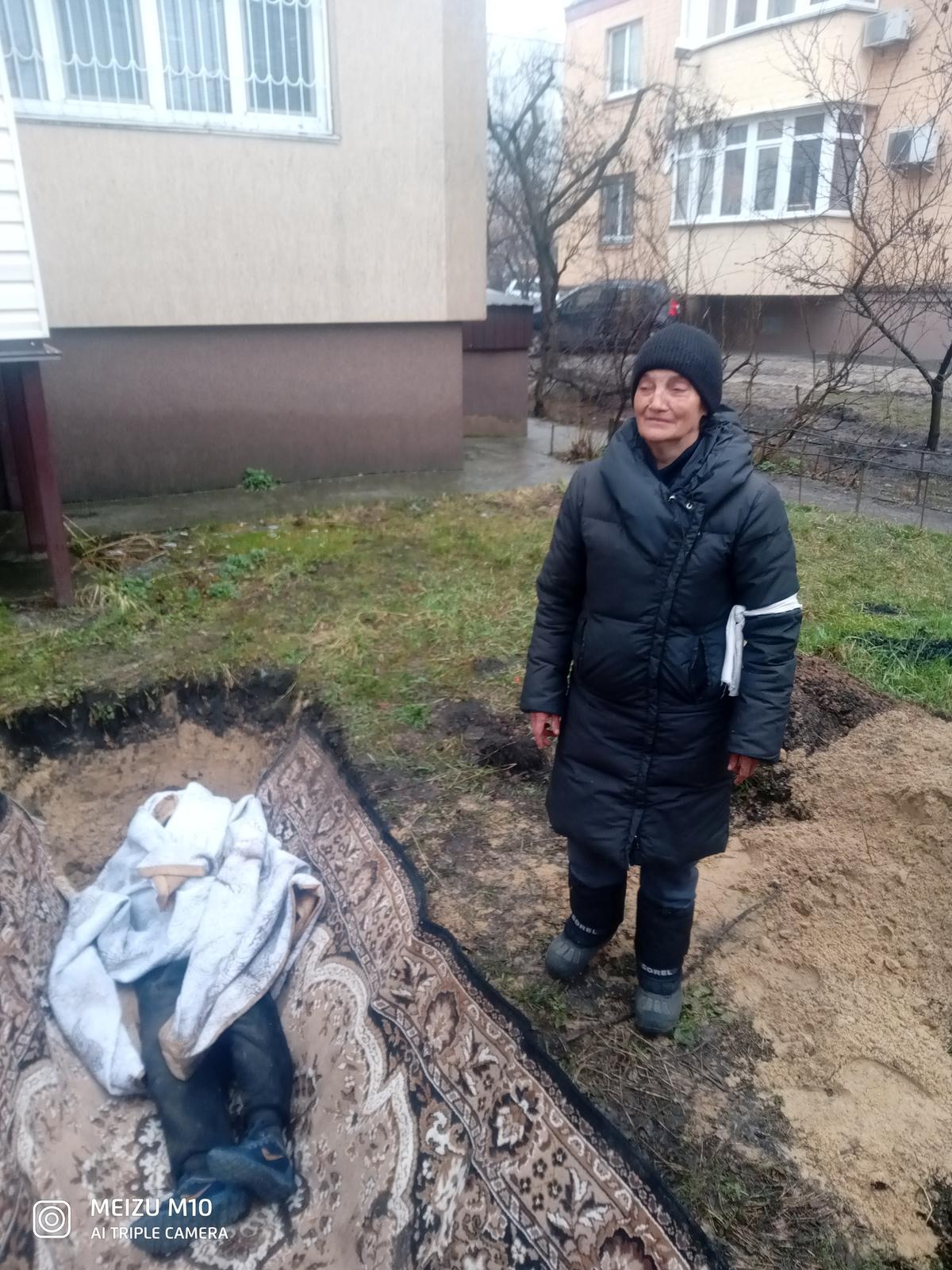 Tetyana Nedashkivska junto a una tumba excavada para su esposo, Vasyl Nedashkivskiy, un residente del complejo, en medio de la invasión rusa de Ucrania, en Bucha, Ucrania, en esta foto sin fecha obtenida por Reuters.