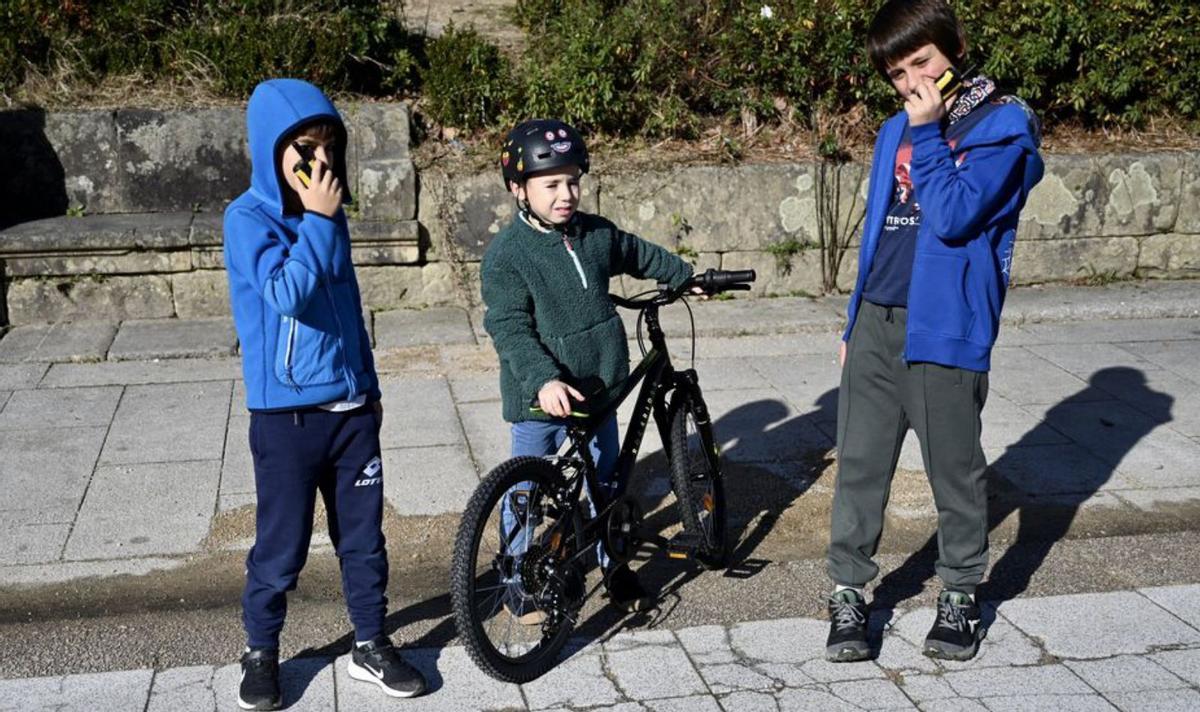 Dos niñas disfrutan del Día de Reyes con sus motocicletas en la Praza de España.   | // RAFA VÁZQUEZ