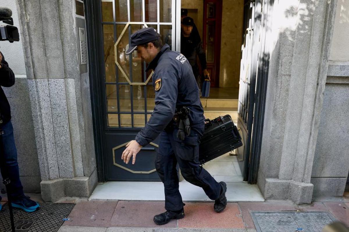 Un agente de la Policía saca un maletín con documentación del despacho del expresidente José Luis Rodríguez Zapatero en la calle Ferraz de Madrid.