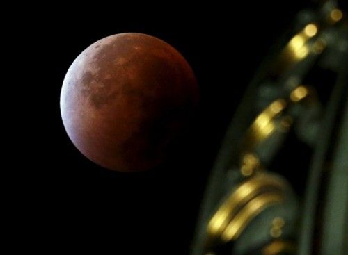 A supermoon rises in the sky next to the Swiss Parliament building in Bern