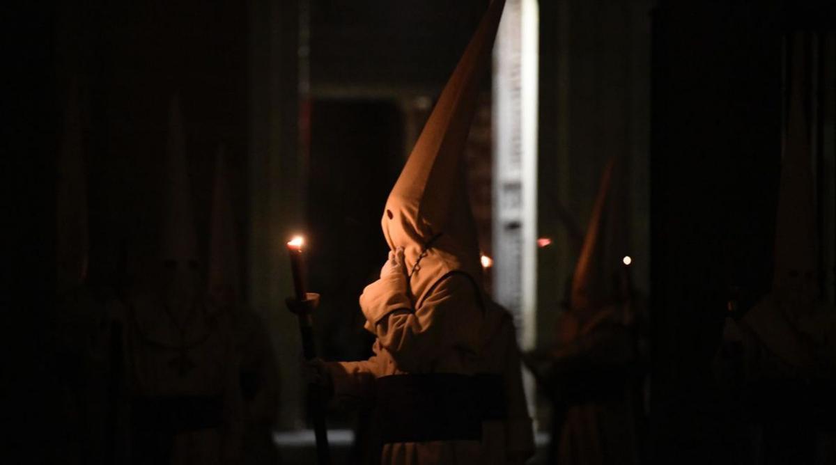 Un hermano iluminado por la vela del hachón. | MIGUEL ÁNGEL LORENZO