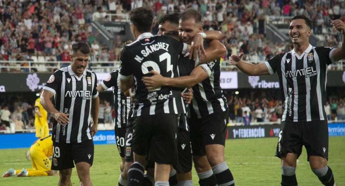 Los jugadores del FC Cartagena abrazan a Pablo de Blasis tras su gol en el último suspiro del encuentro frente al Hércules. | LOYOLA PÉREZ DE VILLEGAS