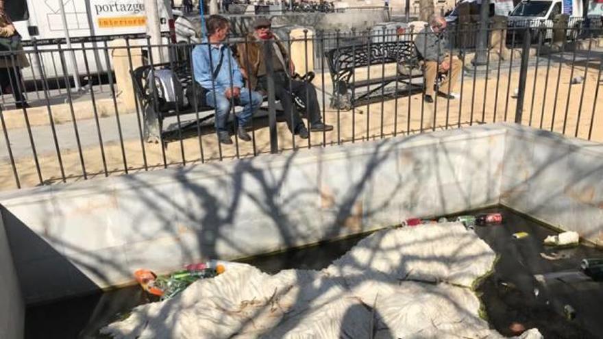 Imágenes tomadas ayer en el mapa-fuente situado en la céntrica plaza de Calvo Sotelo, rodeado de latas y botellas de vidrio en un agua de tonalidad verdosa por el moho.