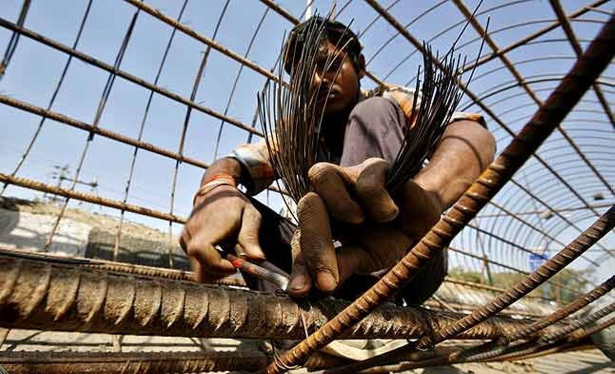 Un obrer treballa amb les barres de reforç de la construcció d’un pont als afores de la ciutat occidental d’Ahmadabad (Índia).