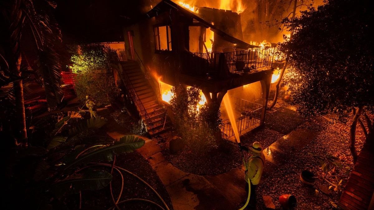 Un bombero tratando de apagar el fuego en una casa en Los Ángeles