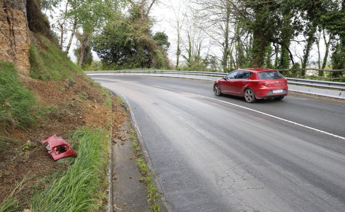 Lugar del accidente donde volcó un autobús, ayer, con restos de carrocería.