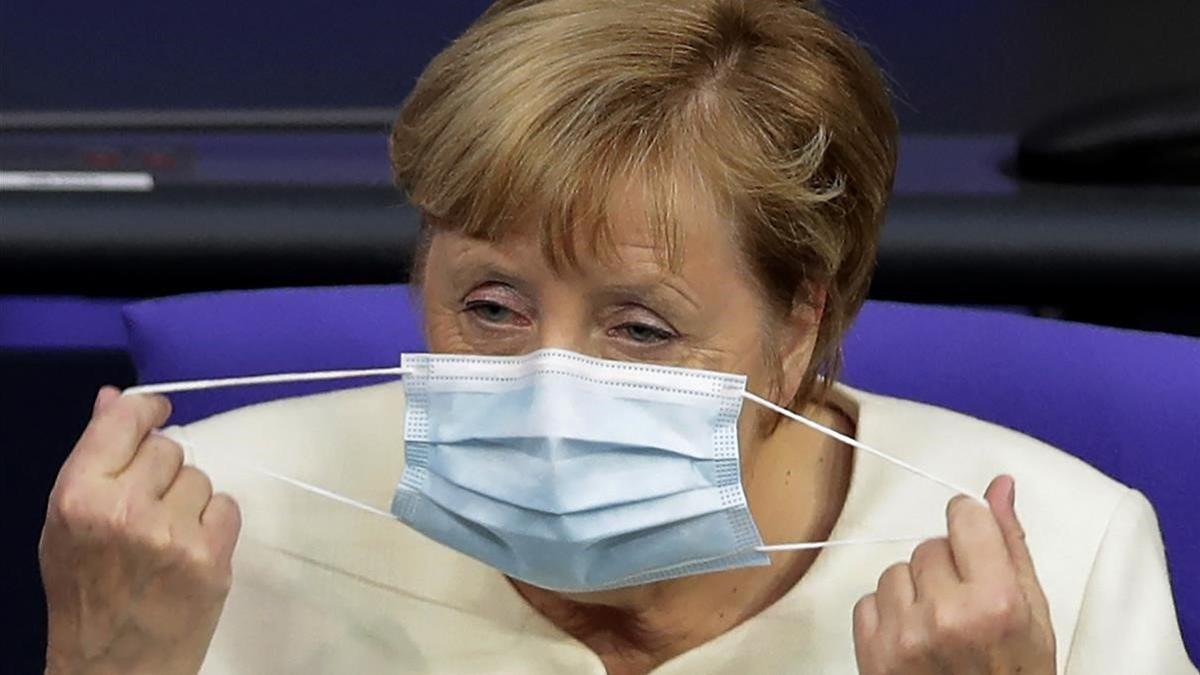 La cancillera alemana, Angela Merkel, se ajusta la mascarilla durante un debate en el Bundestag.