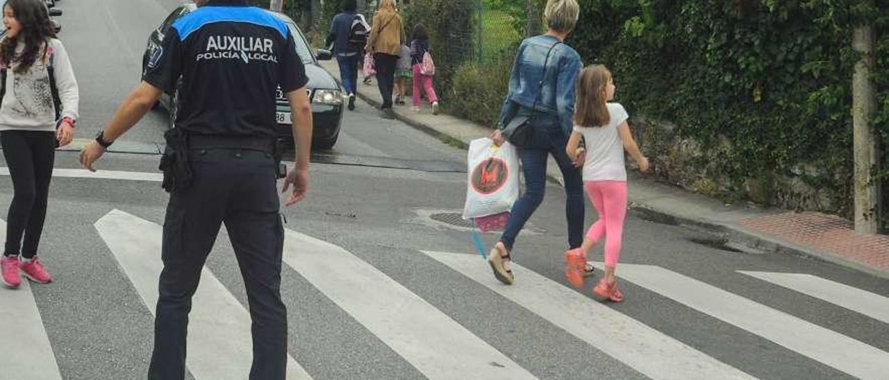 Un auxiliar de Policía Local, en la salida del colegio O Piñeiriño. // Iñaki Abella