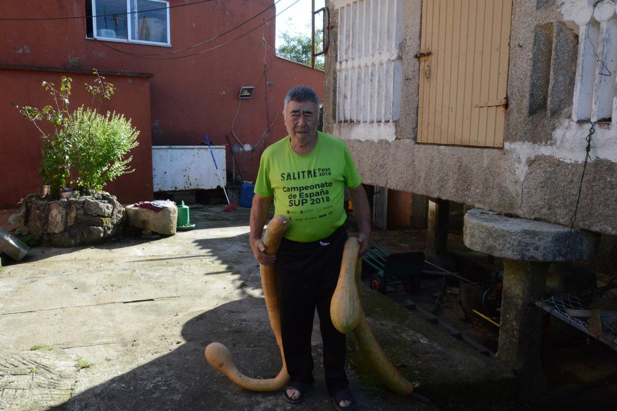 Jesús Fernández con dos de sus calabazas gigantes, en su casa de Bueu.