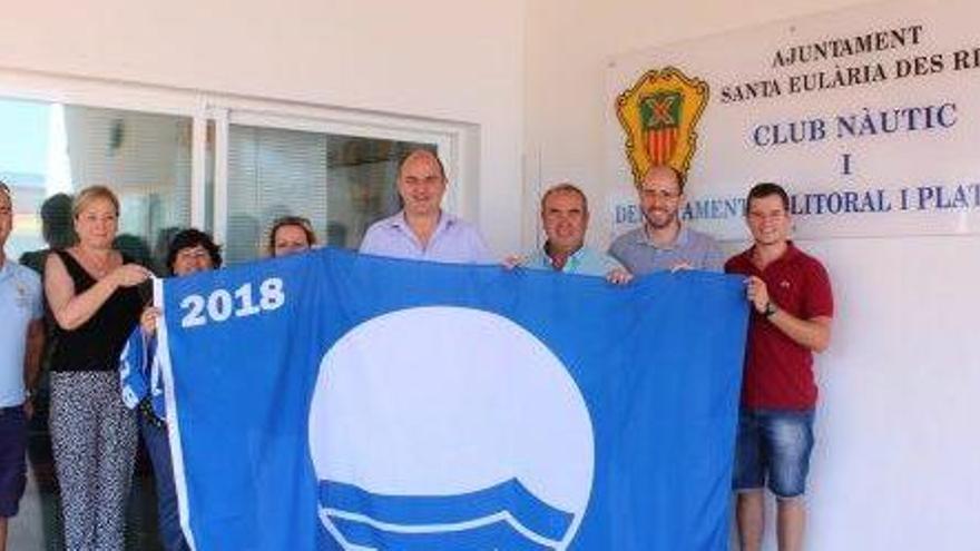 El alcalde, Vicent Marí, muestra una de las cuatro banderas azules para las playas del municipio.