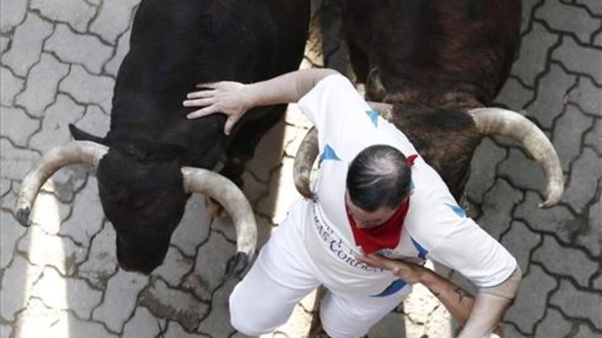 Los toros de la ganadería de La Palmosilla, de Tarifa (Cádiz), a su paso por el tramo del callejón, durante el séptimo encierro de los Sanfermines