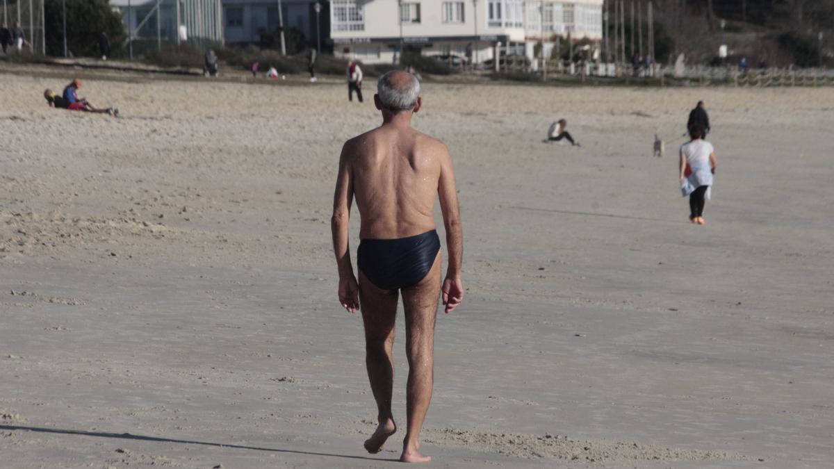 Un vecino pasea por la playa de Rodeira tras darse un baño a principios del pasado mes de febrero.