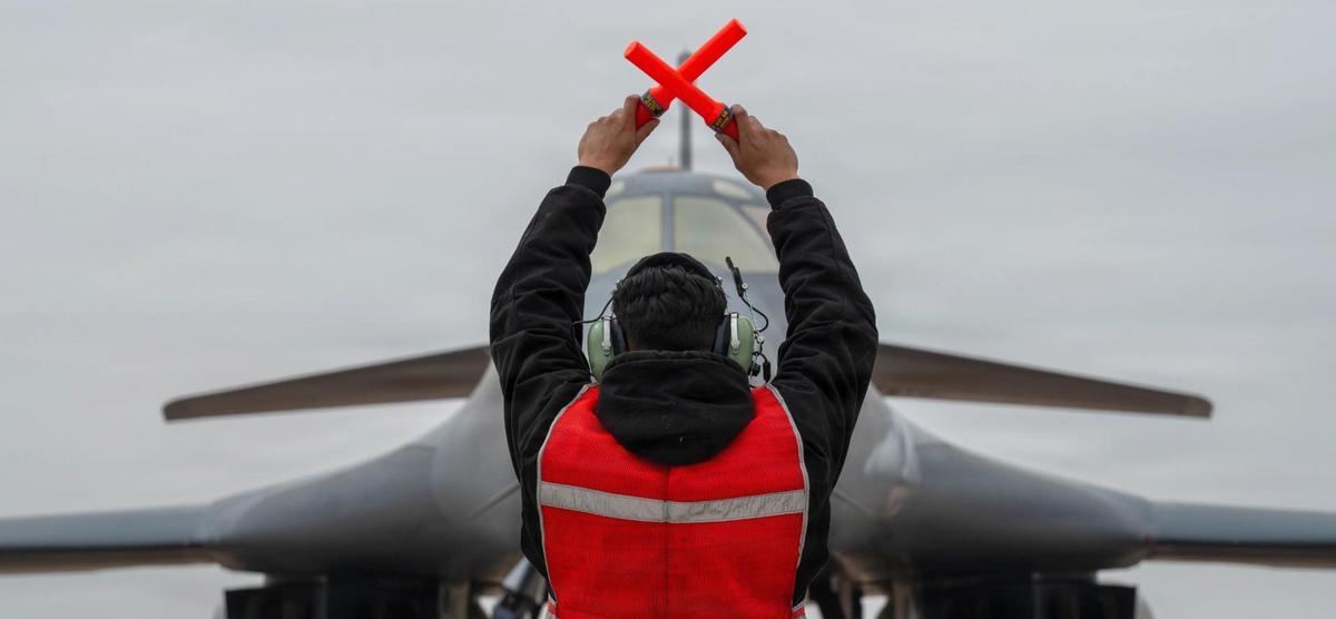 Un assistent en terra guia a un bombarder.