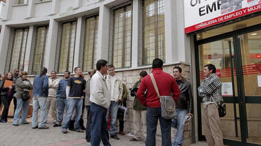 Varias personas haciendo cola en una oficina de empleo.