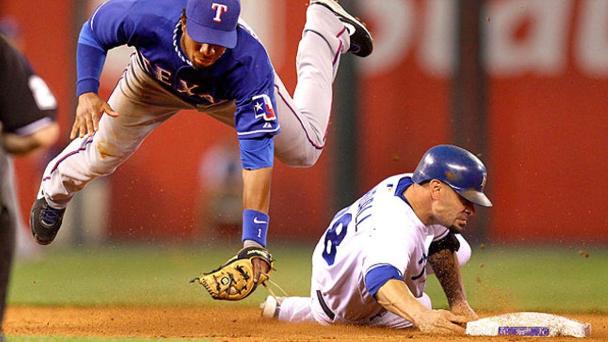 El jugador del Texas Rangers Elvis Andrus salta sobre Jason Kendall, del Kansas City Royal durant la cinquena entrada d’un partit de beisbol.
