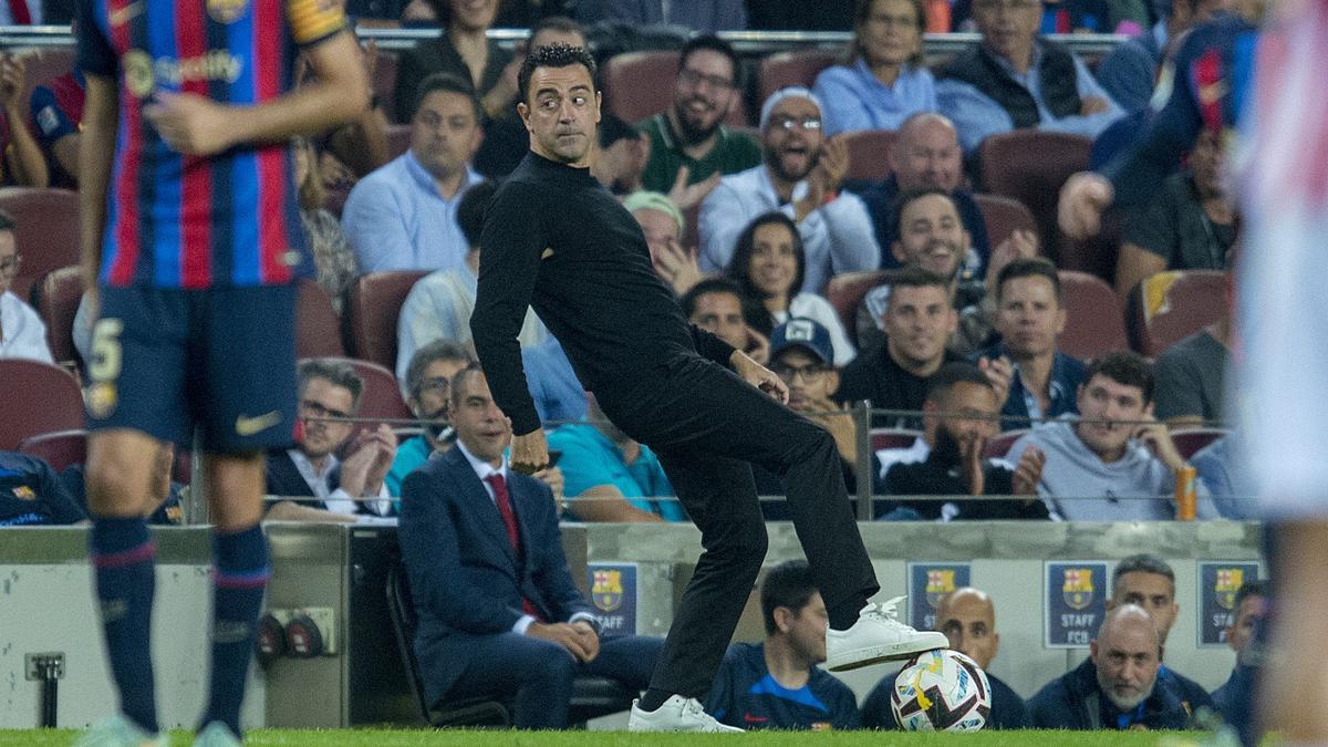 Xavi controla un balón en la banda durante el partido