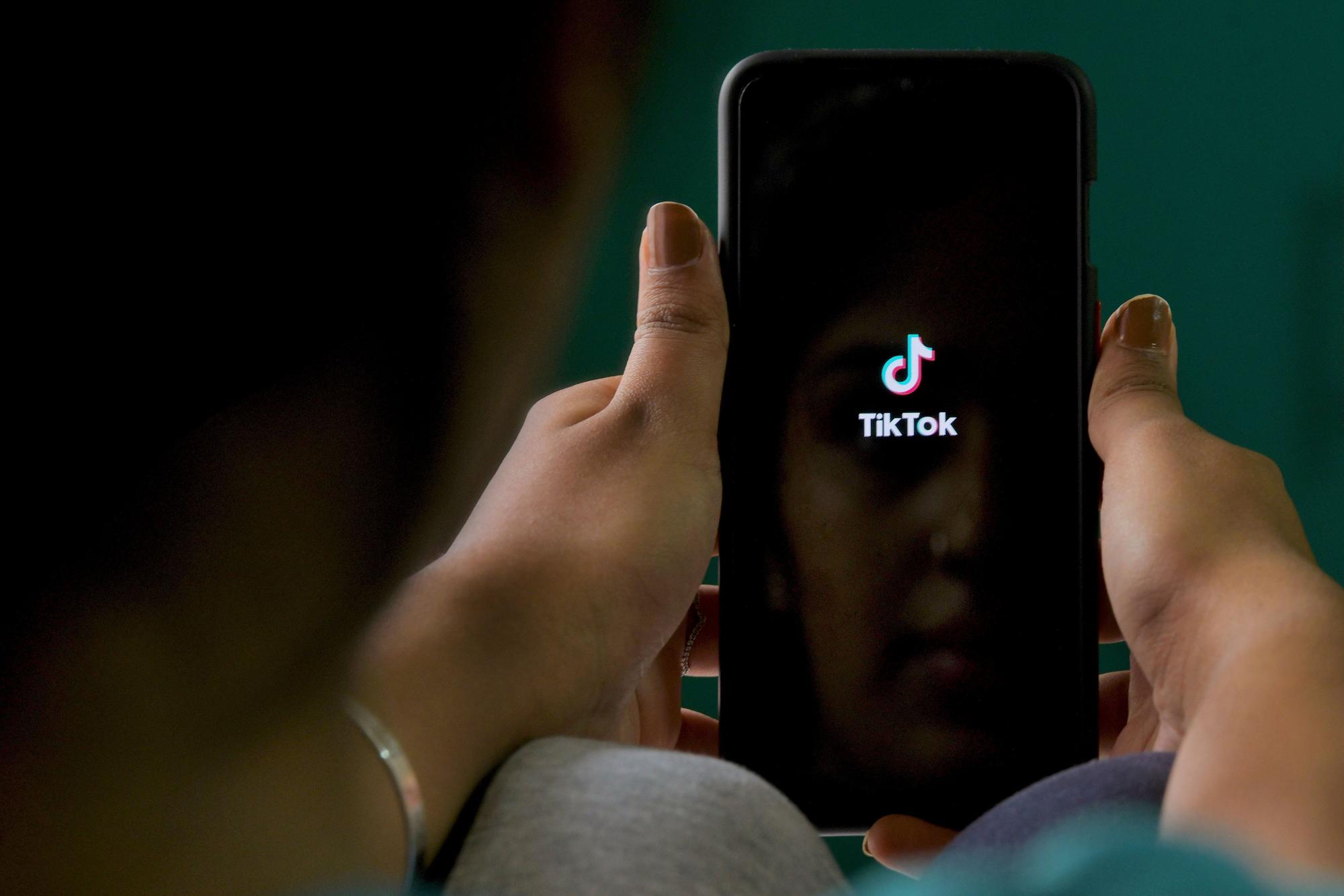 Una mujer abre la aplicación de TikTok en su móvil. 