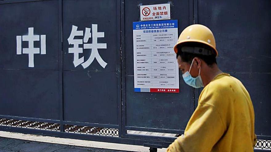 Un joven pasea con mascarilla en China