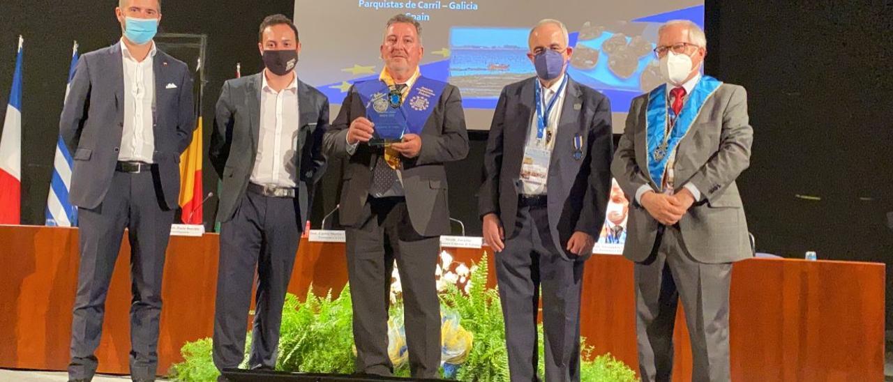 José Luis Villanueva posa con el galardón entregado en Italia  a la agrupación de parquistas de Carril y a su Orde da Ameixa.