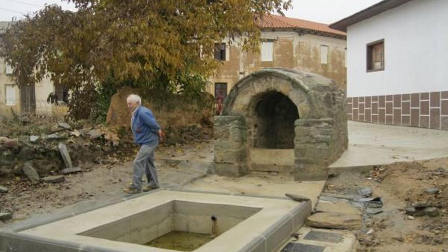 Un vecino de Brime de Sog junto a la fontana del Barrio de Abajo, a punto de concluir su restauración.