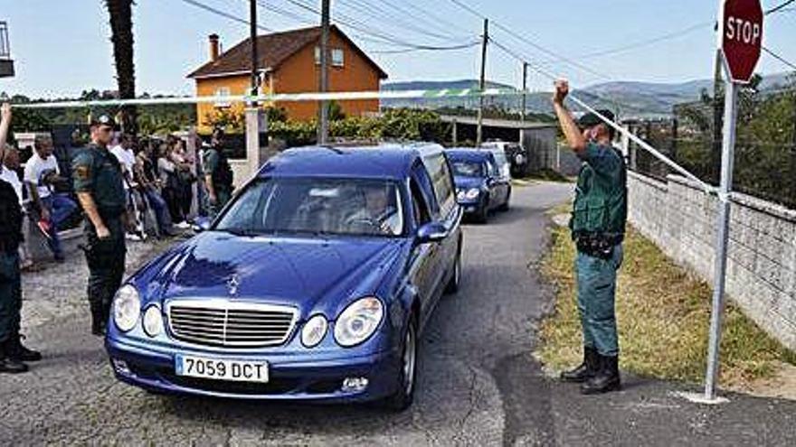 Un cotxe fúnebre s&#039;emporta un dels cadàvers de la casa on es va produir el triple crim