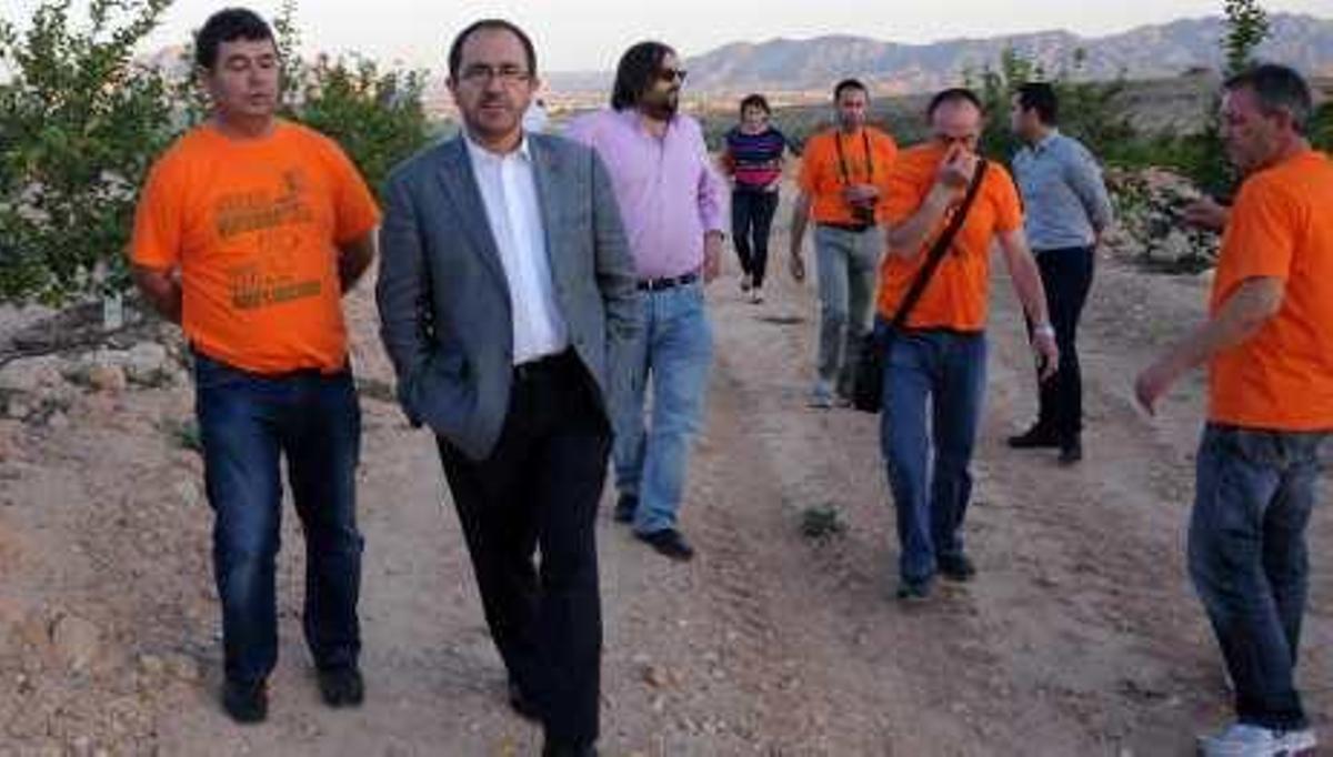 Dos imágenes de la visita ayer al lugar de los enterramientos.