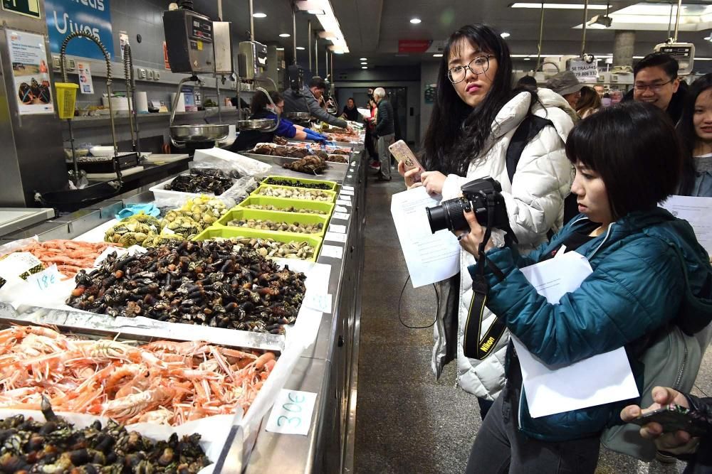 Una treintena de alumnos del Centro de Linguas de la Universidad coruñesa procedentes de China y Vietnam visitan el mercado de la plaza de Lugo para aprender argot gastrónomico gallego.