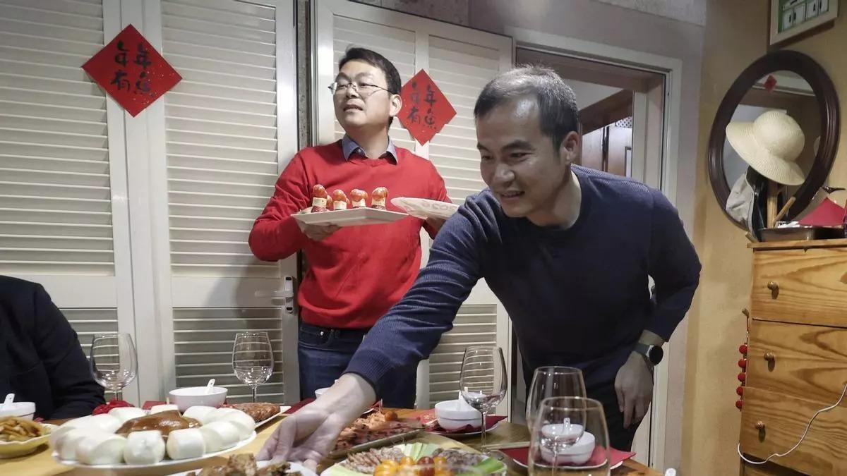 Min Wei coloca algunos platos en la mesa.