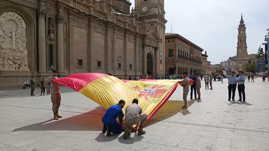 Preparativos para el despliegue aéreo de una bandera de España en la Plaza del Pilar