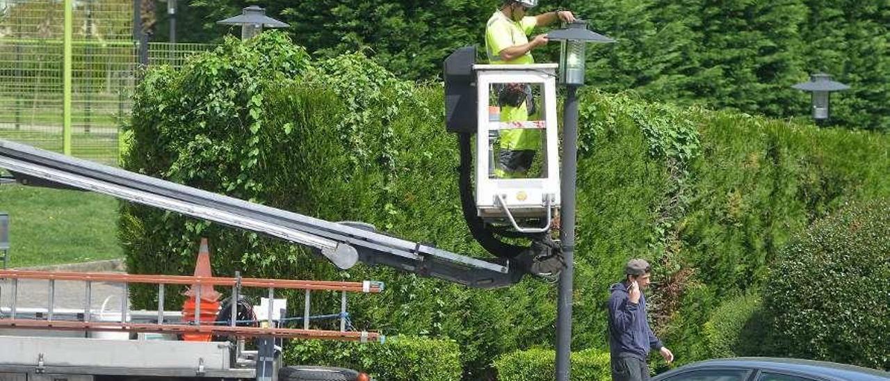 Un operario, arreglando una farola. // Gustavo Santos