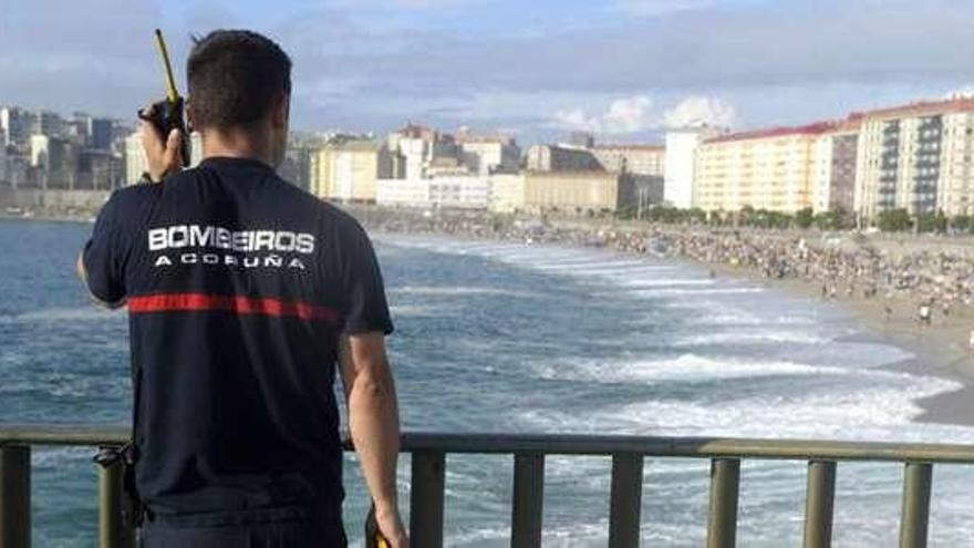 Un bombero observa el inicio del montaje de las hogueras en el Orzán, en el pasado San Juan.