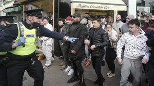 Un policía intenta frenar el avance de los manifestantes este sábado en Dublín. 