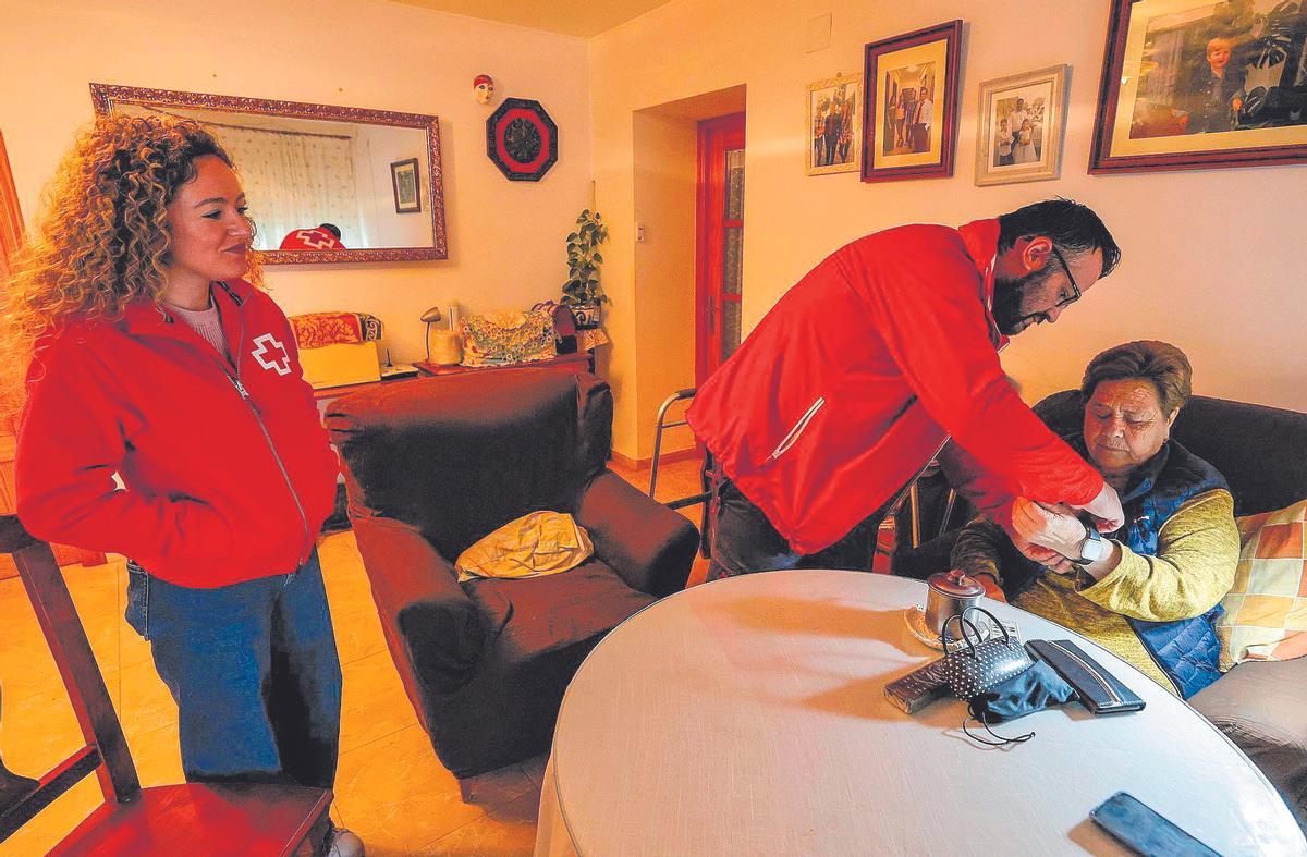 Ana Martín, con Juanjo González y Carla González , de Cruz Roja, en su casa de Carmonita.