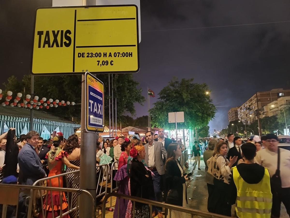 Cola de gente esperando para montarse en un taxi y salir de la Feria de Sevilla de 2026 en la noche del martes al miércoles