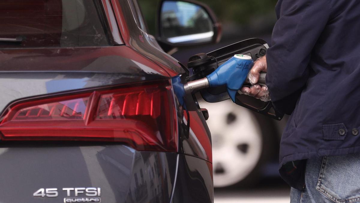 Archivo - Un hombre inyecta carburante a su coche