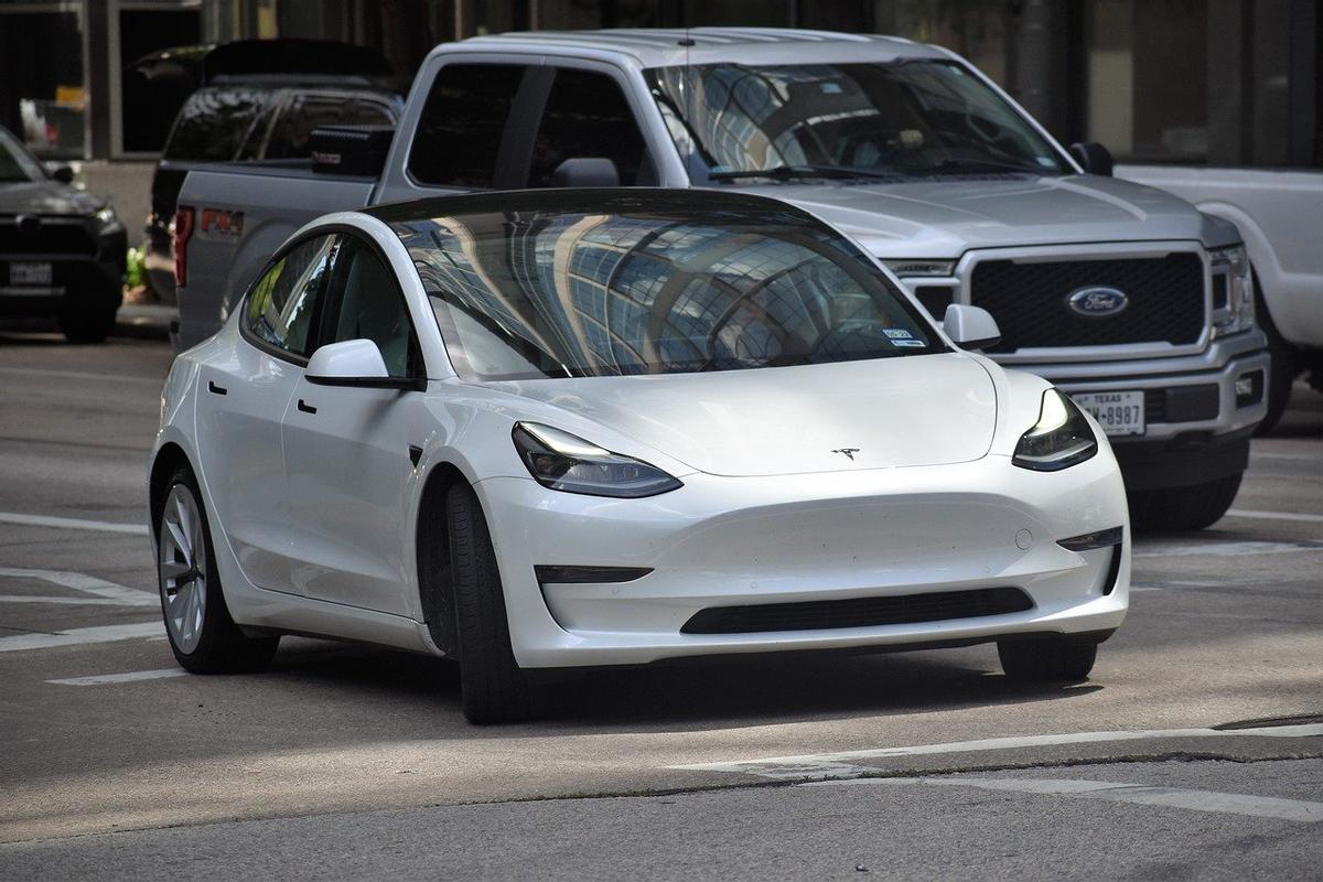 Coche eléctrico de Tesla circulando por una ciudad.