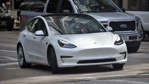 Coche eléctrico de Tesla circulando por una ciudad.